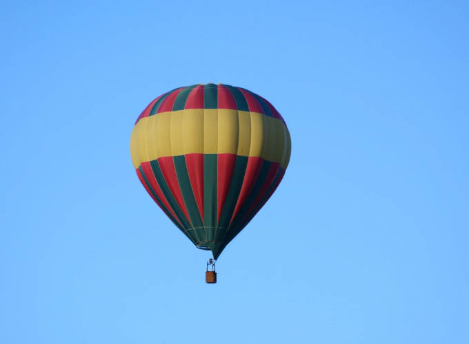 A colorful hot air balloon flying in the sky.