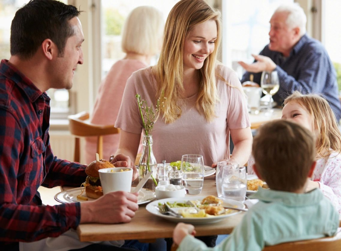 A family sitting at the table eating food.