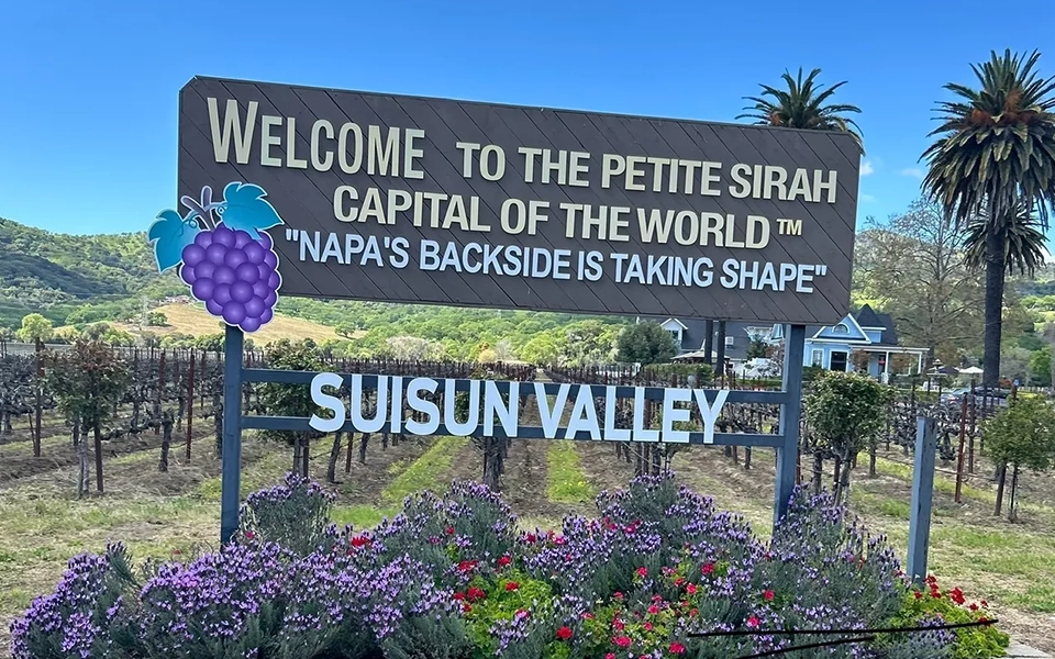 A sign that says welcome to the petite sirah capital of the world.